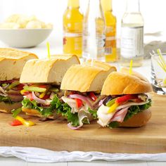 a wooden cutting board topped with cut in half sandwiches