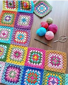 crocheted squares and balls of yarn laid out on a table