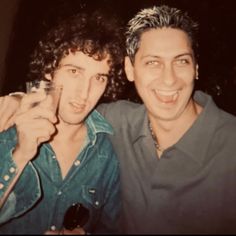 two men posing for the camera with one holding a wine glass in front of his face