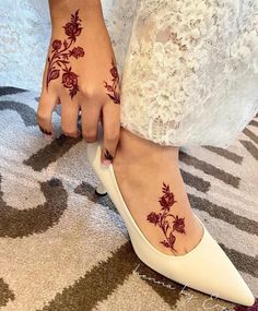 a close up of a person's foot with hennap and flowers on it