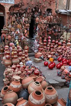 many clay pots are stacked on the ground