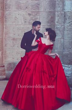 a man standing next to a woman in a red dress