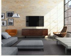 a living room filled with furniture and a flat screen tv mounted on a wall above it