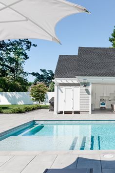 a pool house with an umbrella over it