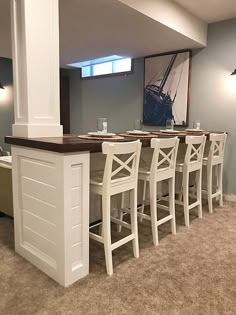 a kitchen island with stools in front of it and a painting on the wall