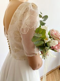 a woman in a white dress holding a bouquet of flowers