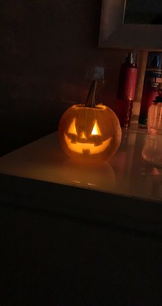 a lit up pumpkin sitting on top of a counter