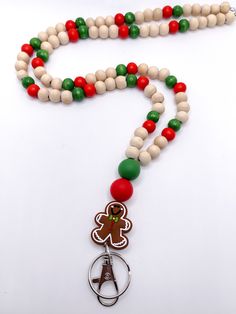 a wooden beaded necklace with a gingerbread cookie charm hanging from it's side