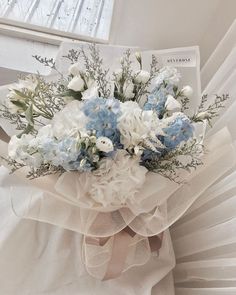 a white and blue bouquet sitting on top of a chair