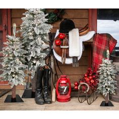 a horse saddle with christmas trees and other decorations on the front door sill in winter