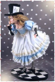 a figurine of a woman in a dress and top hat on a checkered table