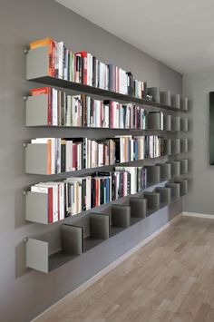 a bookshelf filled with lots of books on top of a hard wood floor