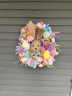 a wreath that is hanging on the side of a house with an animal head in it