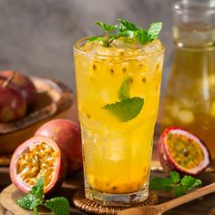 a glass filled with lemonade next to sliced pomegranates