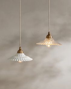 three light fixtures hanging from the ceiling in a room with grey walls and white clouds