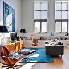 a living room filled with furniture and lots of window sill space in front of two large windows