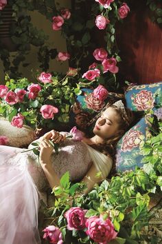 a woman laying on top of a bed covered in flowers