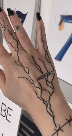 a woman's hand with a black and white tattoo design on her left palm