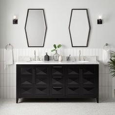 a bathroom with two sinks and mirrors on the wall next to each other in front of a plant