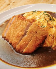 a white plate topped with meat covered in gravy