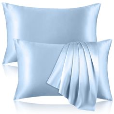 two light blue pillows with satin ribbons on them