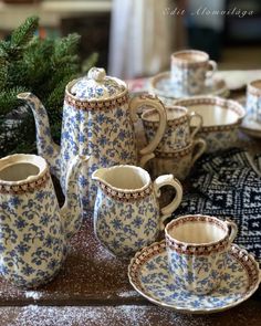 a blue and white tea set sitting on top of a table next to a christmas tree