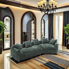 a living room filled with furniture and a chandelier hanging from the ceiling over a large rug