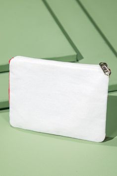 a white purse sitting on top of a green table