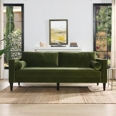 a living room with a green couch and windows