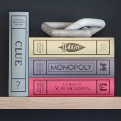 a stack of books sitting on top of a wooden shelf next to a white sculpture