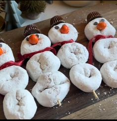 snowmen made out of doughnuts sitting on top of a wooden table