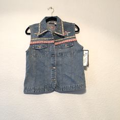 Bill Blass. Vintage Light Wash, Button Front Denim Vest With Floral Embroidery, Gem Embellishments And Floral Patchwork Trim On Bottom. There Are Few Gems Missing. See Pics New With Tag. Dead Stock Bill Blass Size Medium 100% Cotton Approximately Measures 19 Pit To Pit 22.5 Long Y2k Cotton Denim Vest For Spring, Y2k Style Cotton Denim Vest For Spring, Y2k Blue Denim Vest For Spring, Blue Y2k Denim Vest For Spring, Y2k Style Cotton Denim Top For Spring, Embroidered Blue Denim Vest For Summer, Blue Embroidered Denim Vest, Casual Denim Vest With Floral Embroidery For Spring, Summer Embroidered Blue Denim Vest