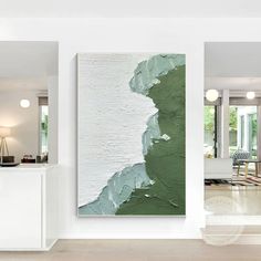 an abstract painting hangs on the wall next to a white table and chairs in a living room