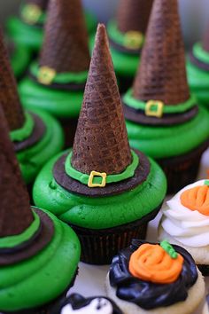 some cupcakes with green frosting and brown hats on top are sitting next to each other