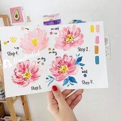 a person holding up a card with watercolor flowers on it and the words step by step