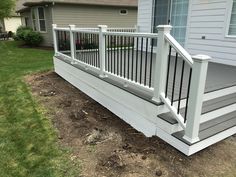 a white porch with railing and steps in front of a house