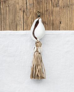 a white vase with a tassel hanging from it