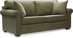 a green couch with two pillows on the back and one arm folded up in front