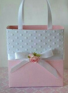 a pink and white bag with a flower on the front is sitting on a table