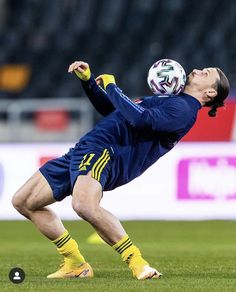 the soccer player is trying to kick the ball in mid air while wearing yellow socks