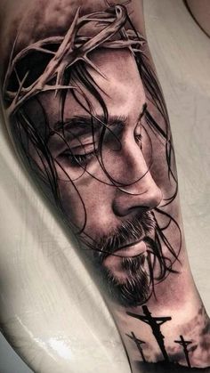 a man's arm with a jesus tattoo on it