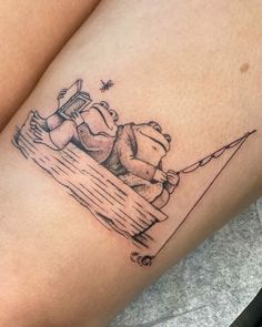 a tattoo on the leg of a woman with a teddy bear sitting on a bench