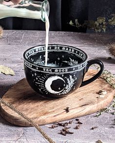 a cup filled with liquid sitting on top of a wooden board