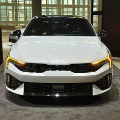 the front end of a white car on display