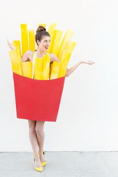 a woman in a red and yellow box holding fries