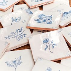 many blue and white plates with designs on them sitting on a wooden table next to each other