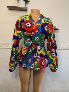 Ankara peplum wrap top is perfect for all occasions including weddings, anniversaries, baby dedication, religious services, bridal showers and parties. It can be worn with skirt, shorts or trouser depending on your choice. This unique piece has a detachable self tie belt and is made with high quality Ankara fabric sourced from Nigeria. Items are shipped from Canada If you have any inquiries, please feel free to start an etsy conversation. CARE INSTRUCTIONS * Hand wash with warm water. * Do not b Multicolor Wrap Blouse, Fitted Tie Waist Blouse For Party, Fitted Multicolor Tops For Wedding, Multicolor Tops For Spring Wedding, Fitted Floral Print Wrap Top, Multicolor Spring Wedding Tops, Spring Wedding Multicolor Tops, African Print Blouse, Peplum Wrap Top