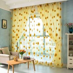 a living room with sunflowers on the curtains and a coffee table in front of it