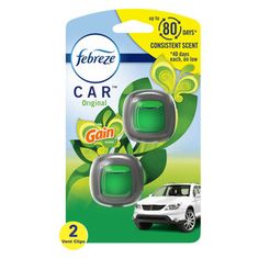 two green car air fresheners are in front of a white car on the packaging