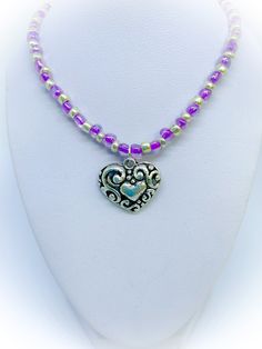 This is a gorgeous Purple and Silver colour Glass Heart Handmade Necklace with Ornate Antique Silver colour heart pendant which features beautiful purple and silver coloured seed beads, The centrepiece is an ornate antique silver colour heart pendant. It is approx 18 inches in length and finished with a silver colour spring ring clasp. To view more JulieDeeleyJewellery items from my shop please click link below : http://www.etsy.com/shop/JulieDeeleyJewellery JULIE DEELEY JEWELLERY SOCIAL MEDIA LINKS Follow me on Facebook: www.facebook.com/juliedeeleyjewellery Follow me on Twitter: twitter.com/julie_deeley Follow me on Pinterest: pinterest.com/juliedeeley Follow me on Instagram: http://instagram.com/juliedeeley Purple Round Beaded Jewelry For Mother's Day, Heart Pendant Jewelry With Colorful Beads For Gift, Double Heart Beads Necklaces For Jewelry Making, Adjustable Colorful Beads Necklace For Valentine's Day, Adjustable Heart Necklace With Heart Beads And Pendant, Adjustable Heart Pendant Necklace With Heart Beads, Heart-shaped Colorful Beads Jewelry For Gifts, Heart-shaped Beaded Jewelry For Gifts, Silver Beaded Necklaces With Heart Beads For Gift